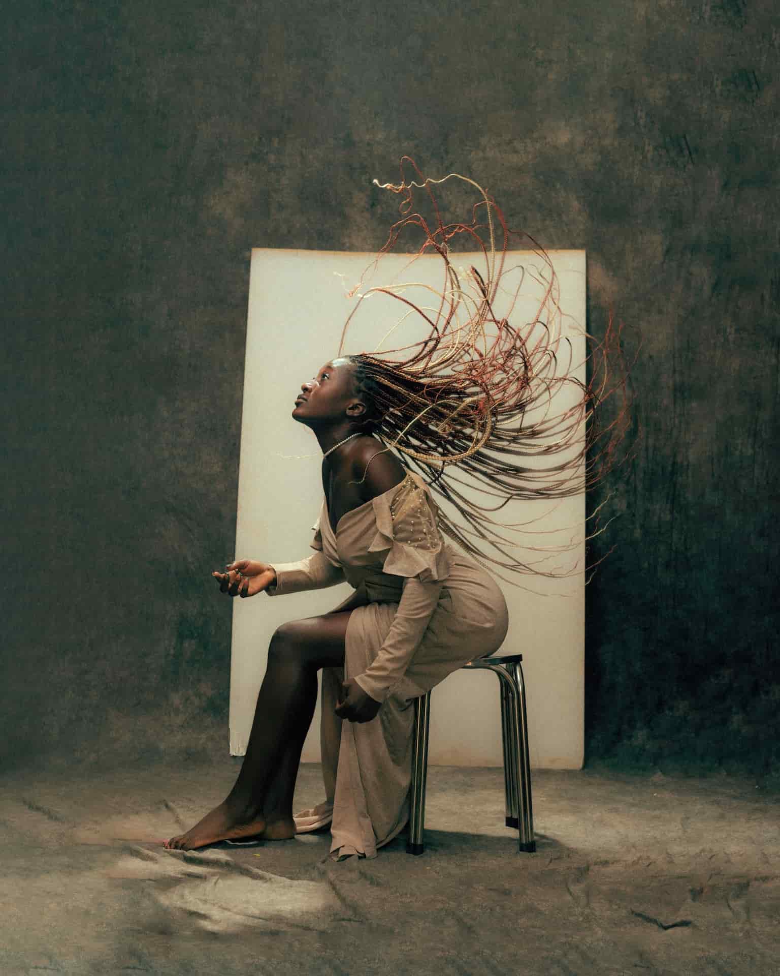 Is Photography Art Model with Dreadlocks In Front of Backdrop